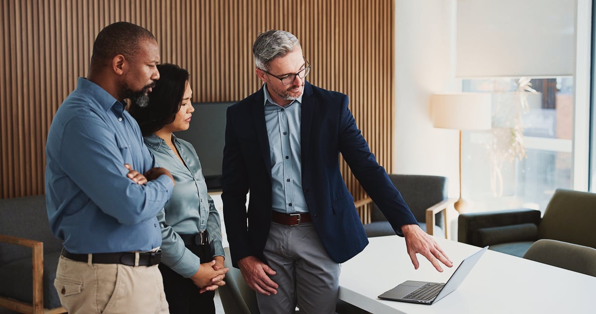 Consulting team collaborating over a laptop in an office